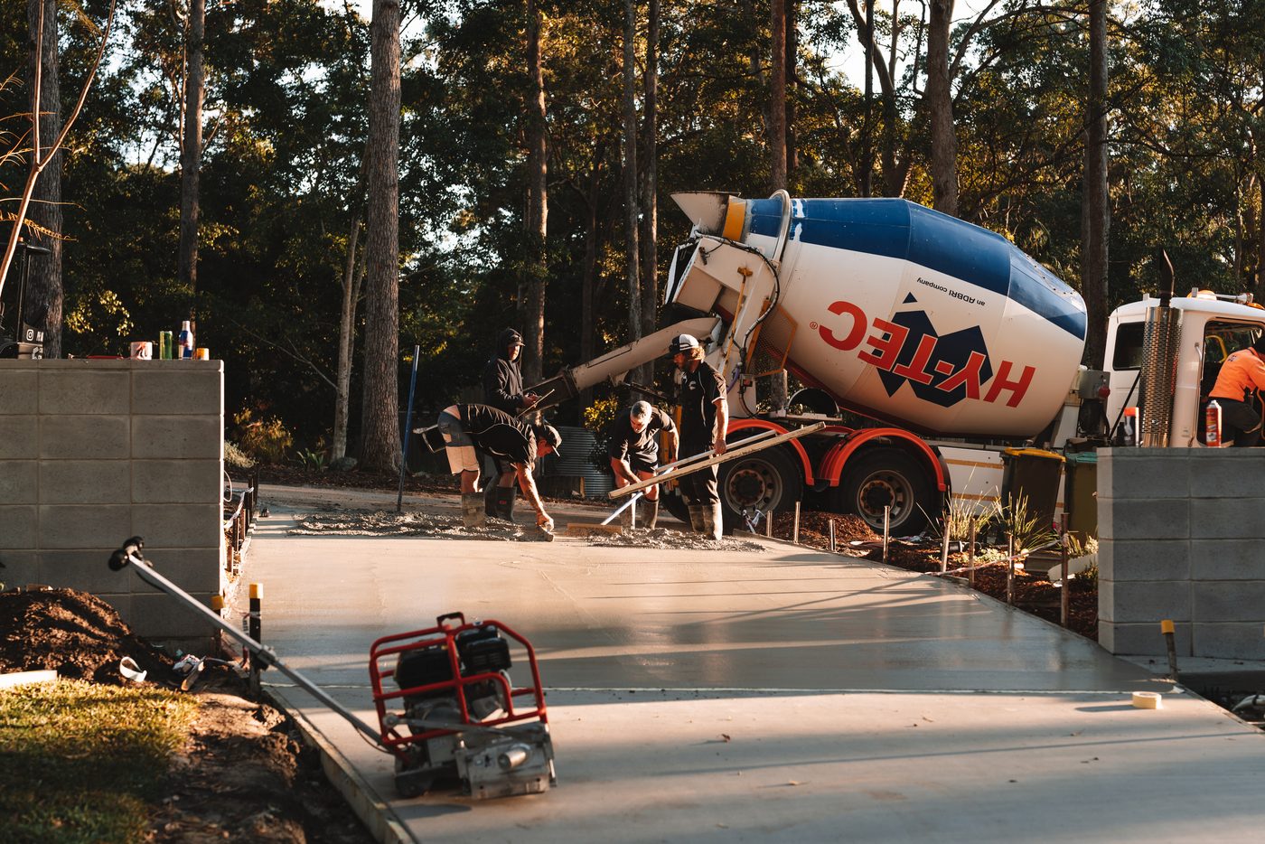 Working the surface of a fresh pour beside the retaining wall