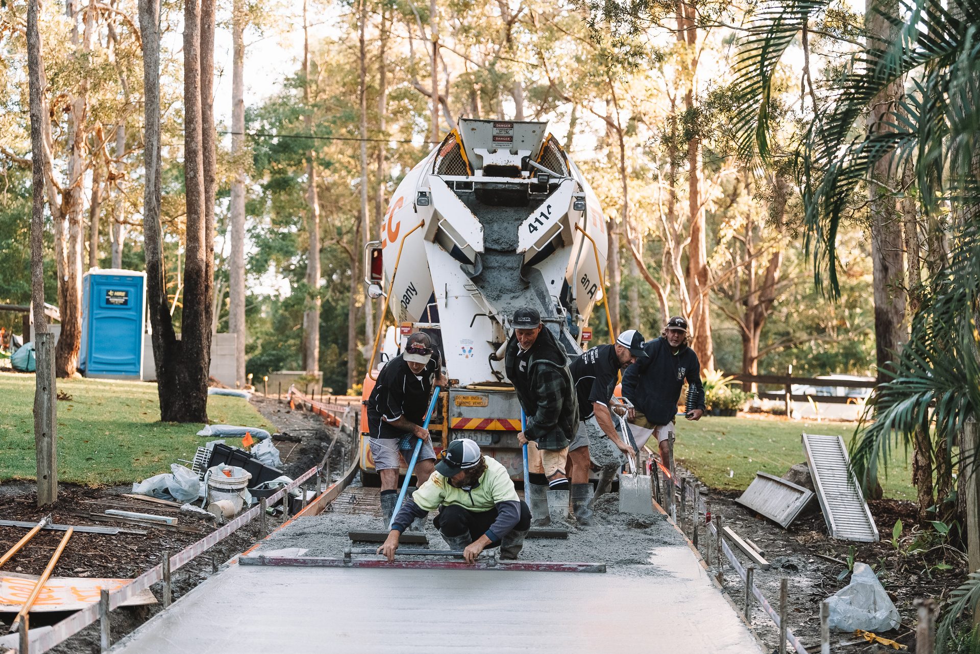 Concrete truck and crew placing a driveway pour