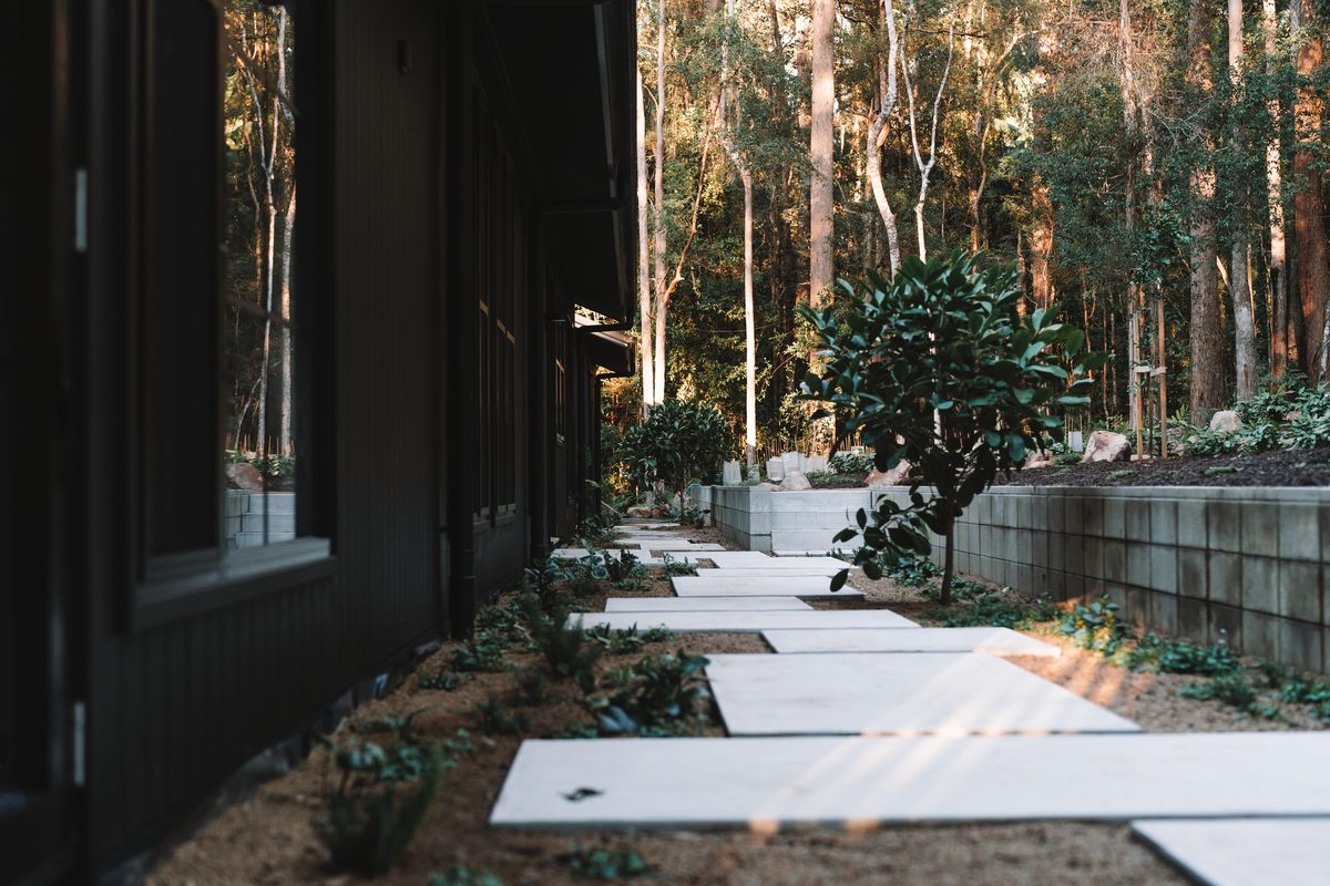 Concrete stepping stones set into landscaping beside a home